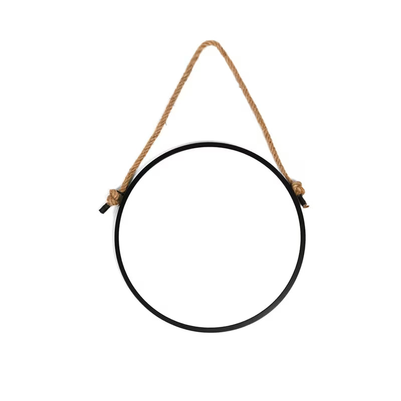 Okruglo viseće ogledalo Naturel s metalnim okvirom u mat crnoj boji, obješeno na čvrsto uže.