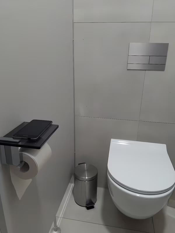 Crni držač toaletnog papira SAT Cube Way s odlagališnom policom od kaljenog sigurnosnog stakla.