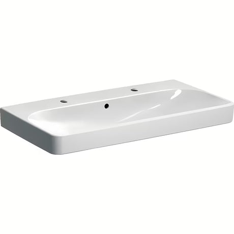 Bijeli viseći umivaonik Geberit Smyle Square 90x48 cm od sanitarne keramike s dva otvora pro za slavinu.