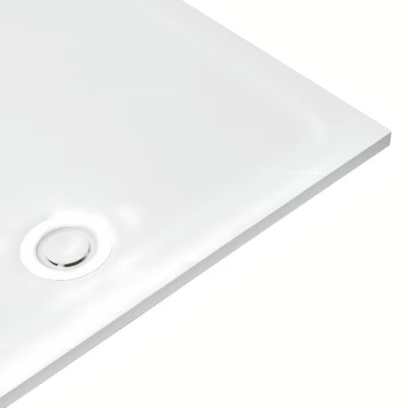 Bijeli dizajnerski sifon za tuš kadu s pokrivnom kapicom, koji ne strši iznad površine kade.